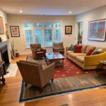 Living room with layered rugs — striped kilim base rug under red patterned area rug with seating arrangement