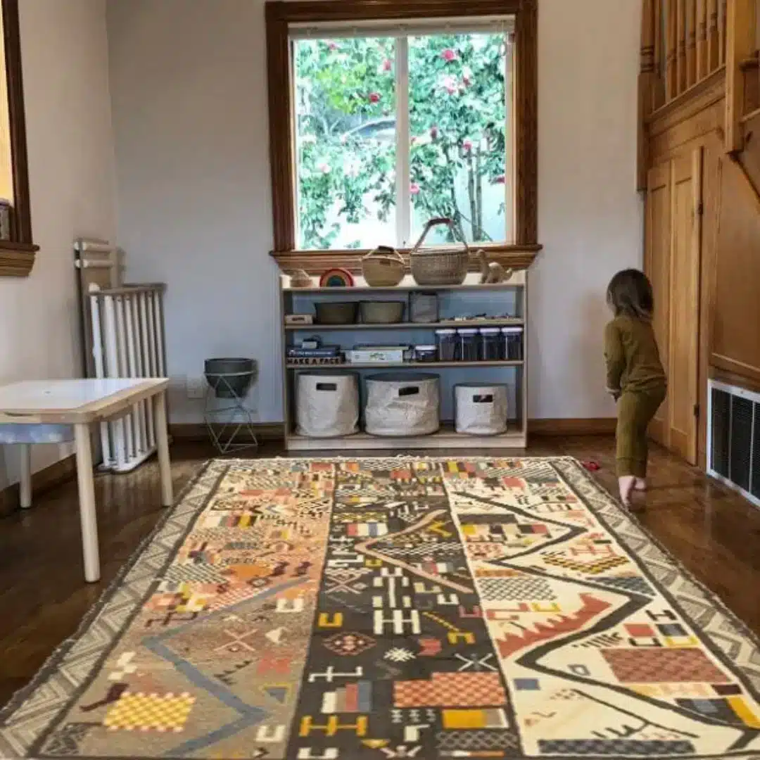 patterned washable rug in a children’s playroom with wooden furniture and natural light